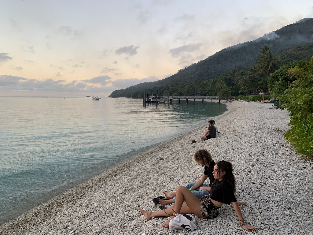 Fitzroy Island beach at sunset with rocky shore