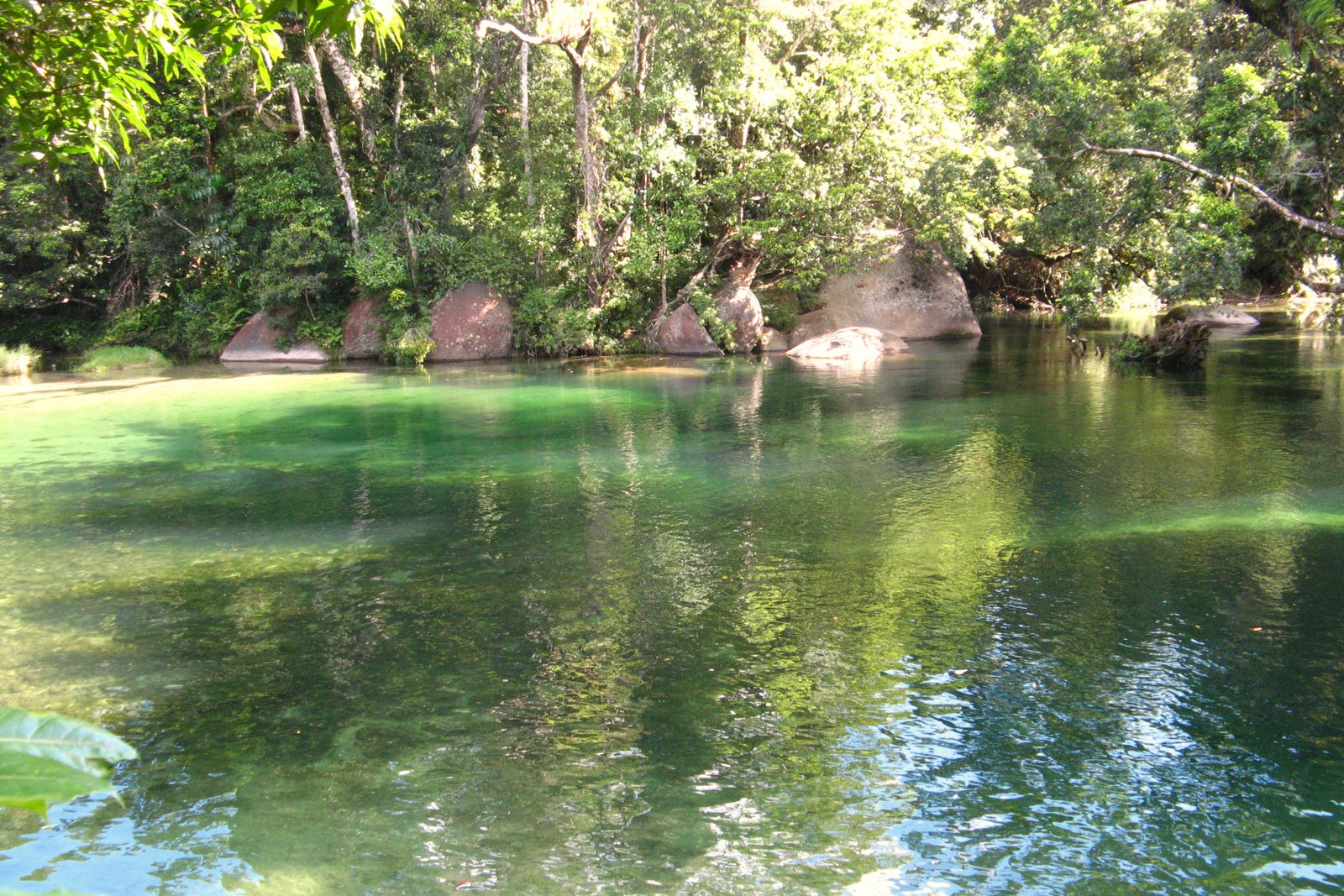 The clear green swimming hole at Babinda Boulders, surrounded by granite rocks and rainforest south of Cairns