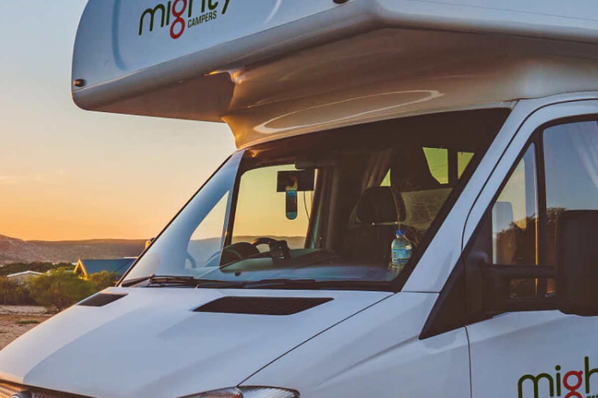 A Mighty campers motorhome parked by the coast at sunset
