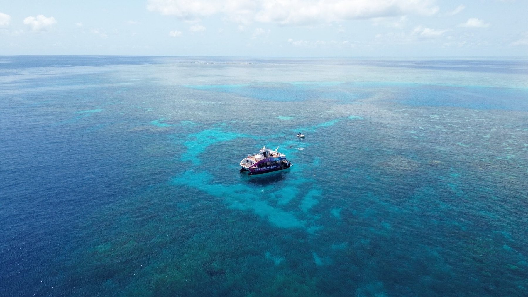 Aerial view of the reef with the Pure Snorkelling vessel at anchor