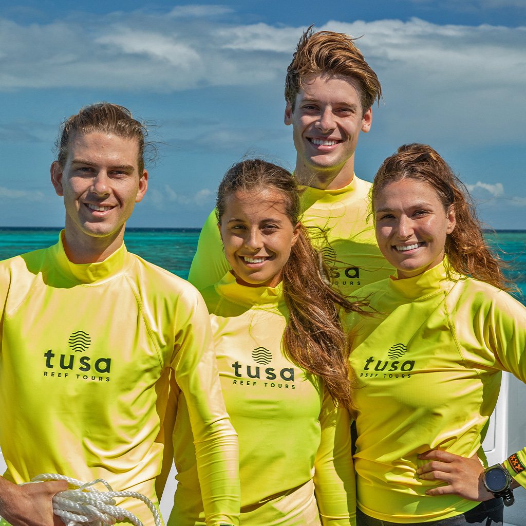 Tusa Reef Tours crew in branded rash shirts