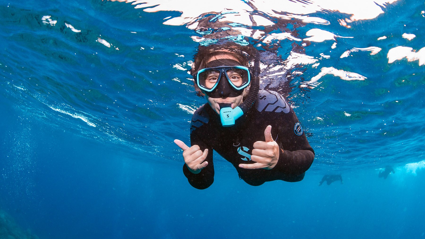 Snorkeller giving a thumbs up underwater on the reef